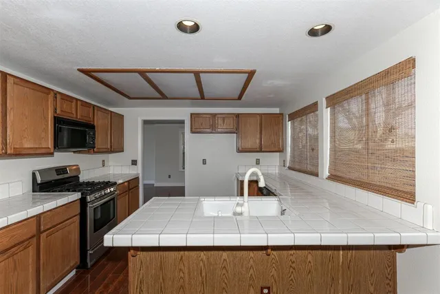 a kitchen with stainless steel appliances a sink stove and microwave