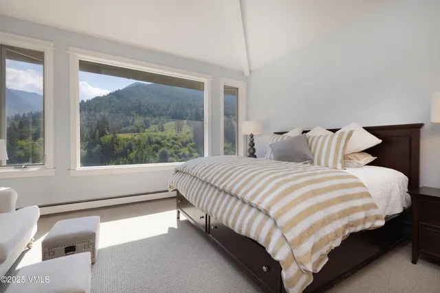 a bedroom with a bed and a large window