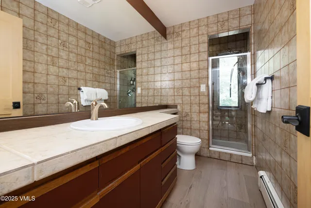 a bathroom with a granite countertop sink toilet and shower