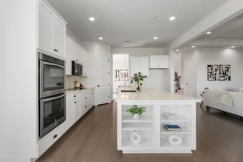 a kitchen with kitchen island white cabinets and refrigerator