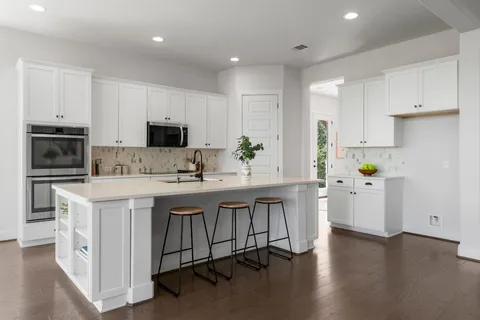 a kitchen with white cabinets and stainless steel appliances