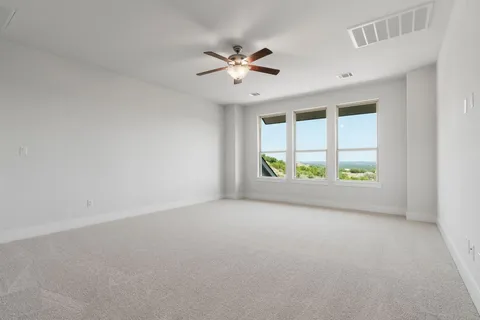 an empty room with a window and a ceiling fan