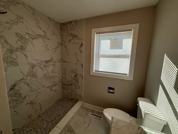 a view of empty room with window and wooden floor
