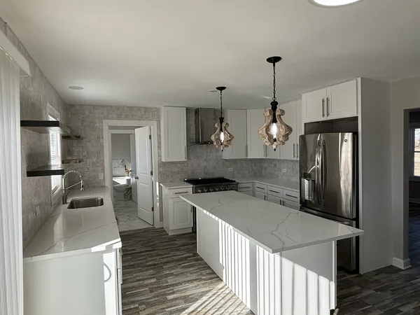 a bathroom with a granite countertop sink a toilet and a window