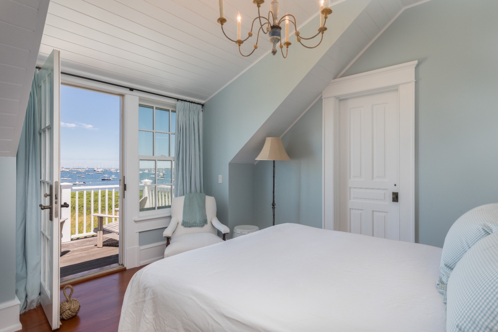 20 Berkeley Avenue Nantucket, MA 02554 - Photo 28 of 30 a bedroom with a large bed and a chandelier