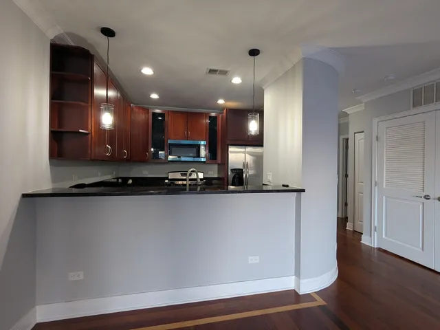 a view of a kitchen with kitchen island and stainless steel appliances