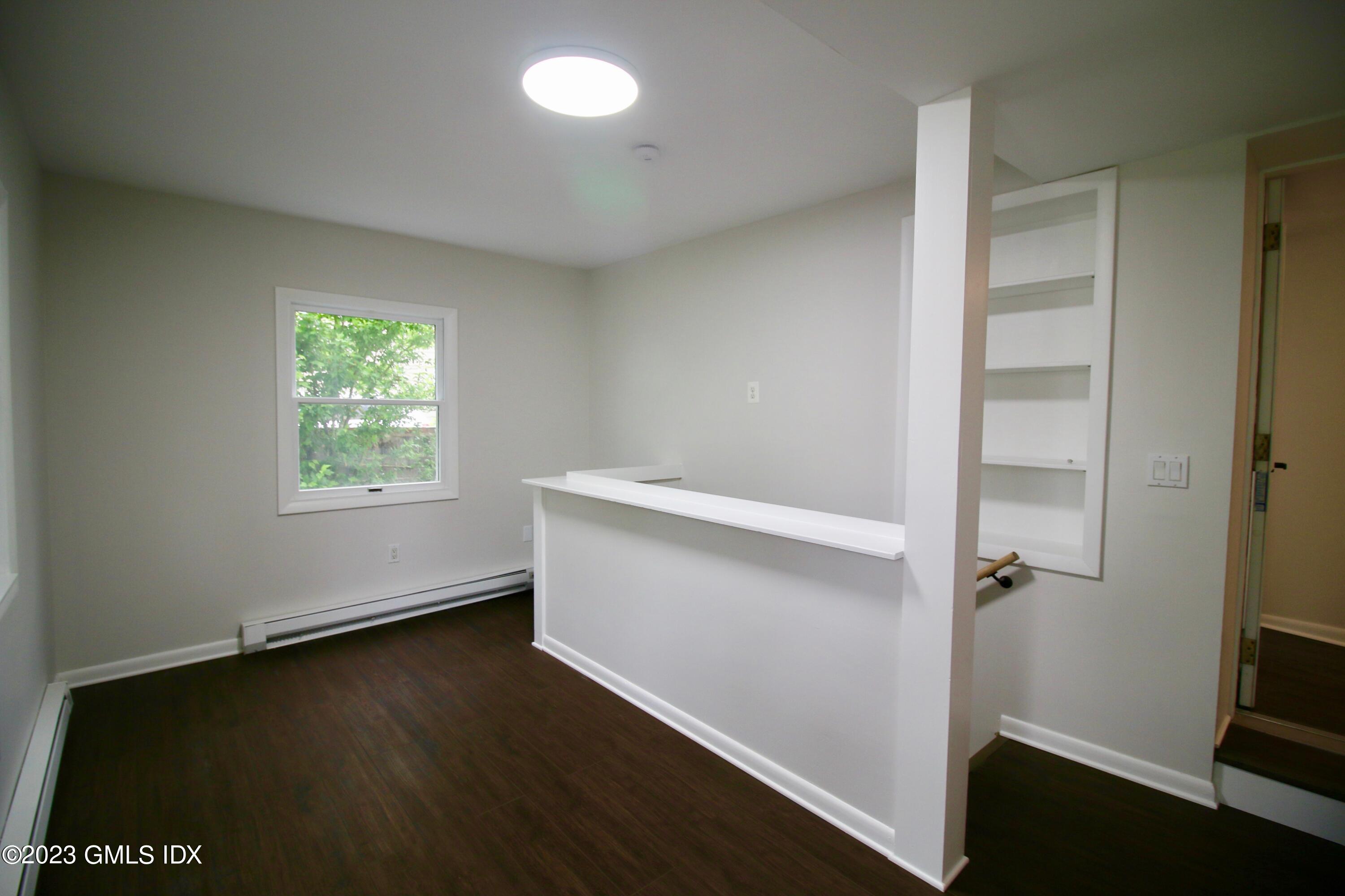 25 Bible Street, Unit 1 Cos Cob, CT 06807 - Photo 4 of 12 an empty room with wooden floor and windows
