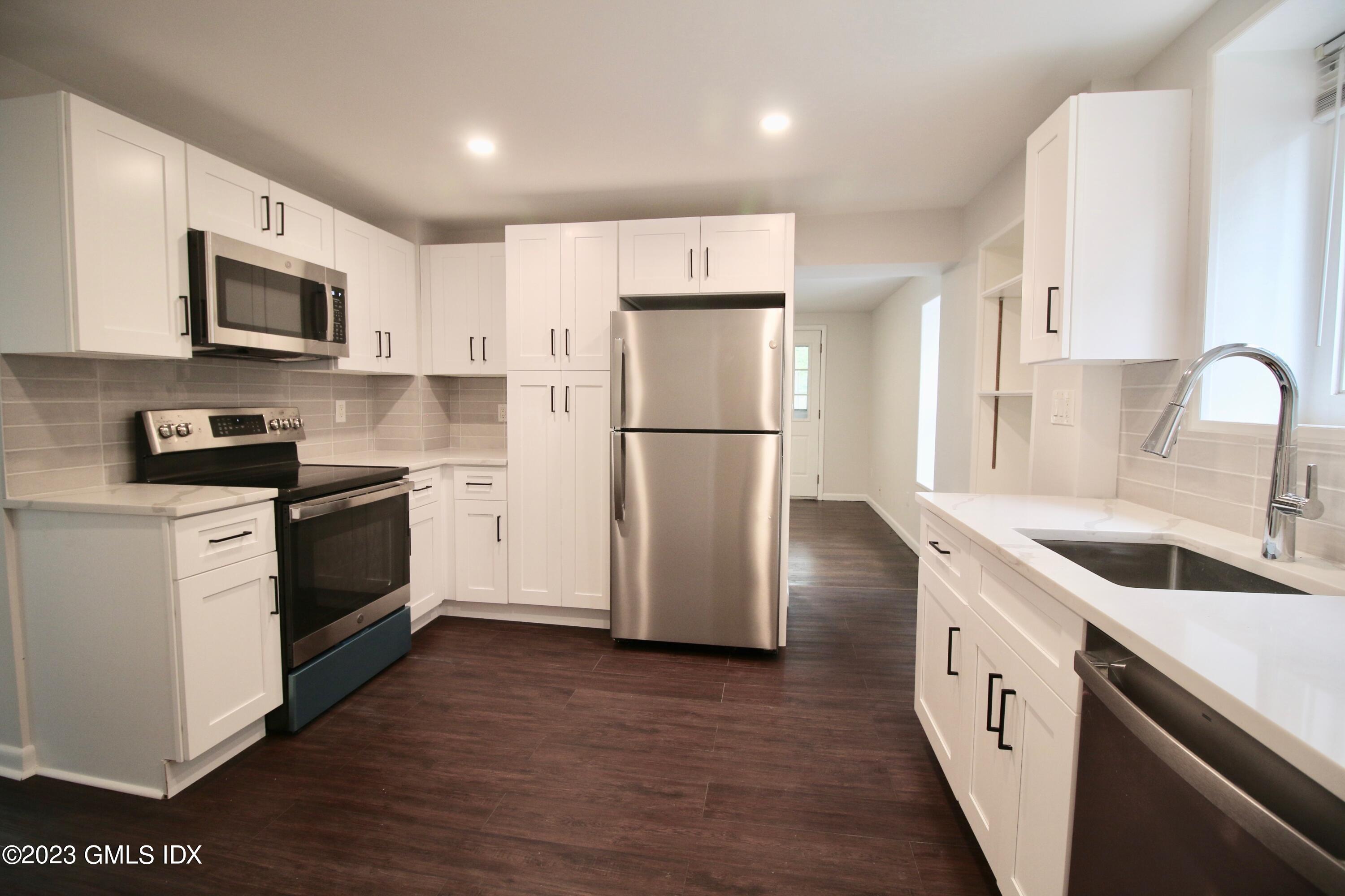 25 Bible Street, Unit 1 Cos Cob, CT 06807 - Photo 5 of 12 a kitchen with a refrigerator sink and white cabinets