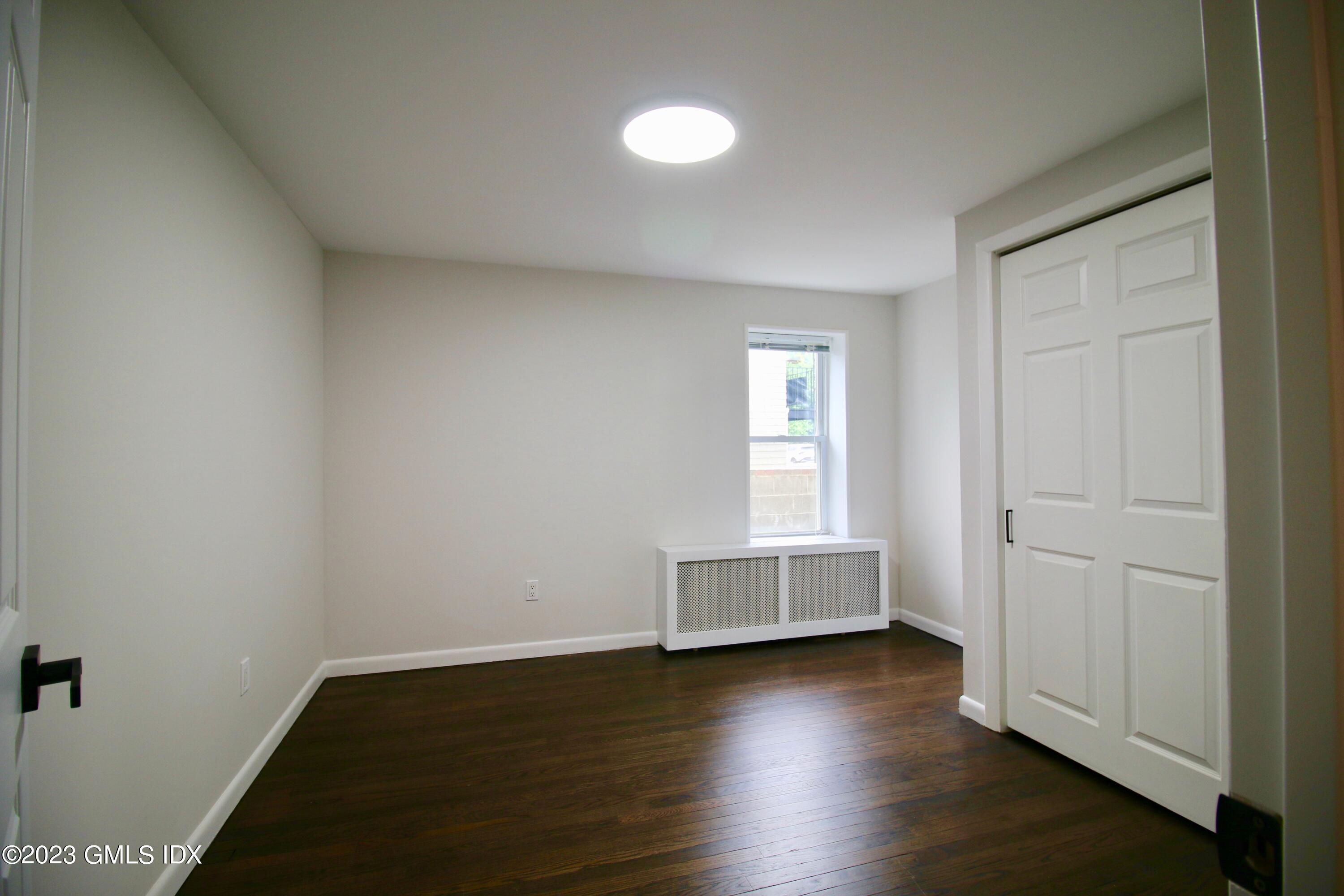 25 Bible Street, Unit 1 Cos Cob, CT 06807 - Photo 6 of 12 an empty room with wooden floor and windows