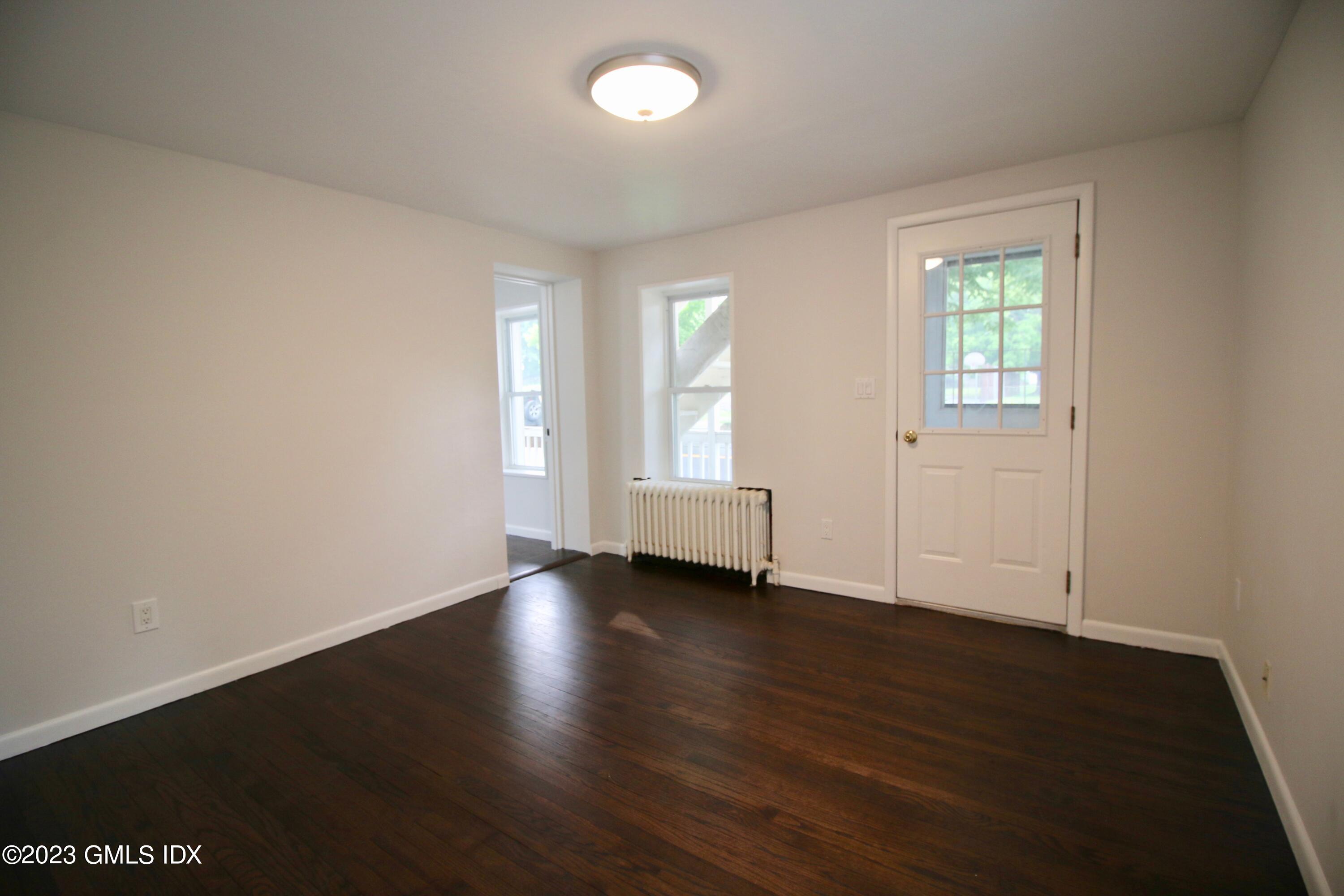 25 Bible Street, Unit 1 Cos Cob, CT 06807 - Photo 7 of 12 an empty room with wooden floor and windows