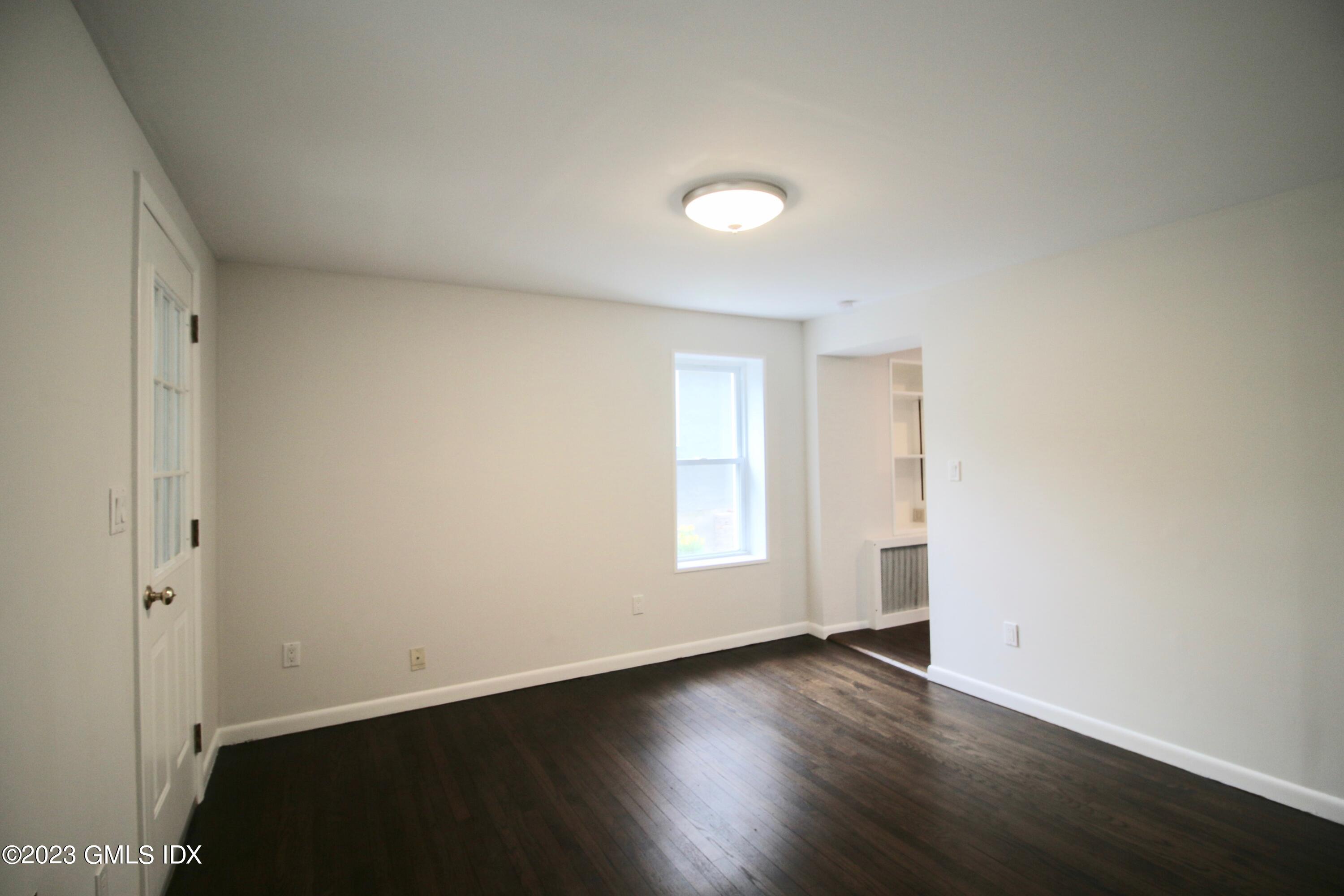 25 Bible Street, Unit 1 Cos Cob, CT 06807 - Photo 9 of 12 an empty room with wooden floor and window