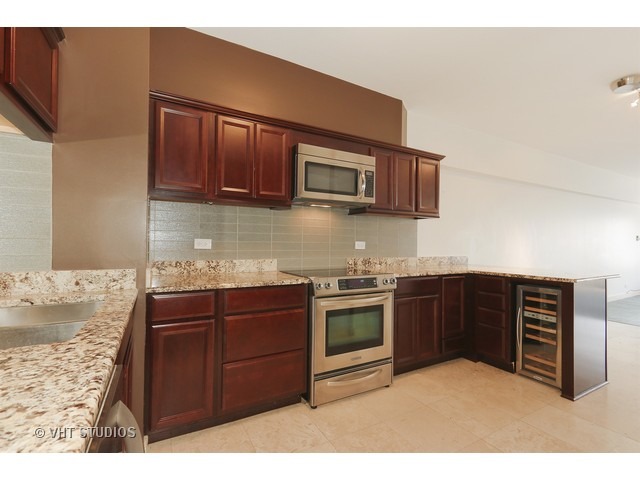 175 East Delaware Place, Unit 6001 Chicago, IL 60611 - Photo 2 of 10 a kitchen with stainless steel appliances granite countertop a stove top oven microwave and cabinets