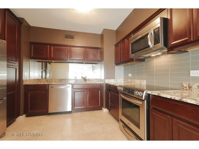 175 East Delaware Place, Unit 6001 Chicago, IL 60611 - Photo 3 of 10 a kitchen with stainless steel appliances granite countertop a sink stove and microwave