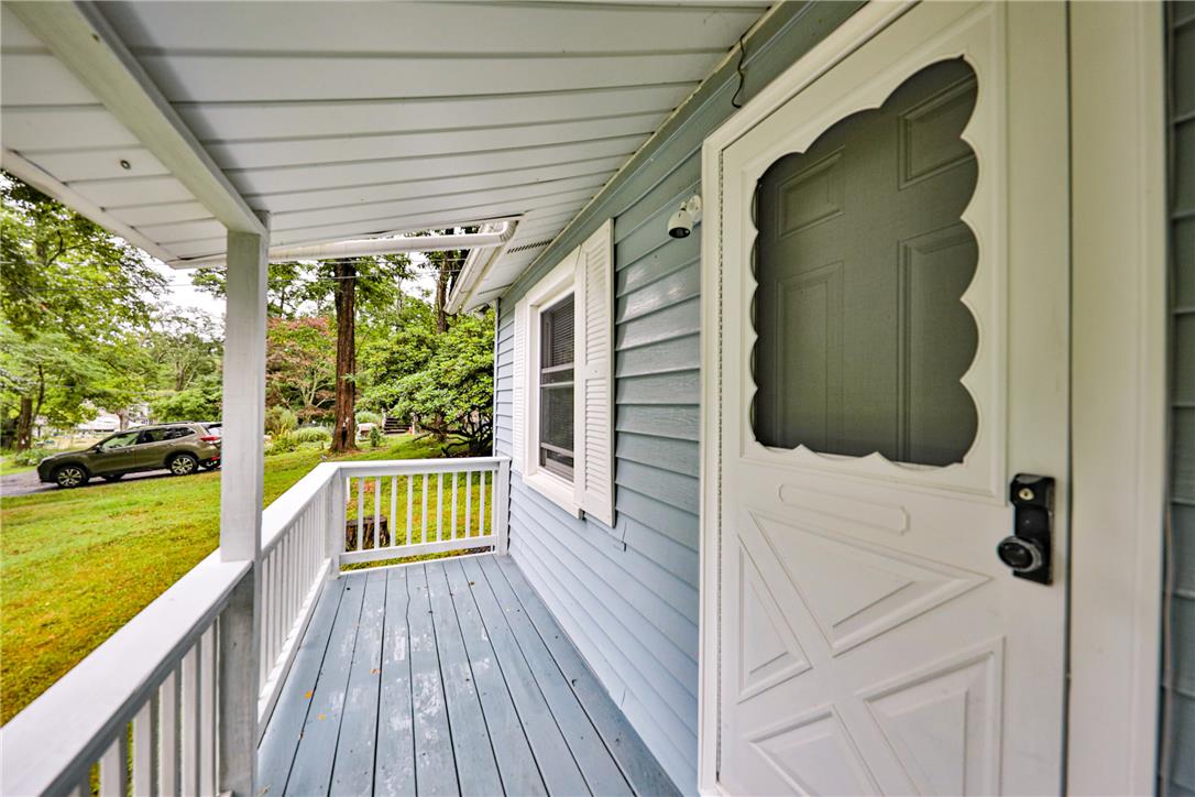 5599 Minks Pond Road Bushkill, PA 18324 - Photo 35 of 64 A charming covered porch welcomes visitors, offering a peaceful spot to relax outdoors.