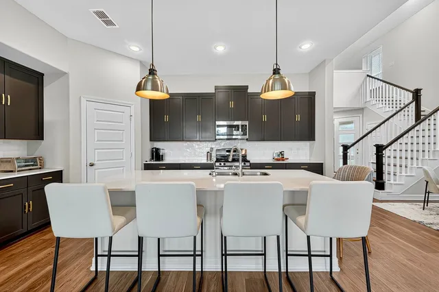 a kitchen with a sink a counter space appliances and cabinets