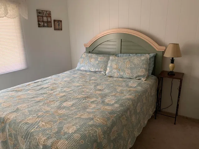 a bedroom with a bed and dresser with mirror