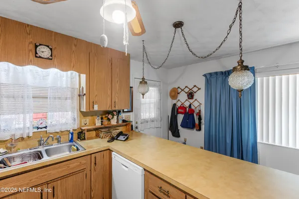 a view of a kitchen with a sink and chandelier