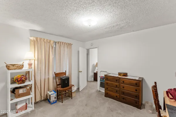 a view of a bedroom with workspace and windows