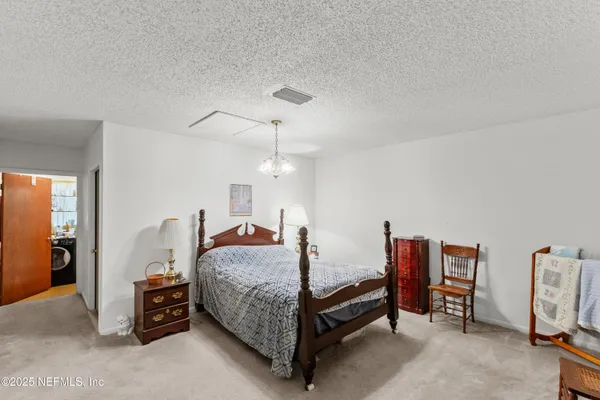 a bedroom with bed and a chandelier
