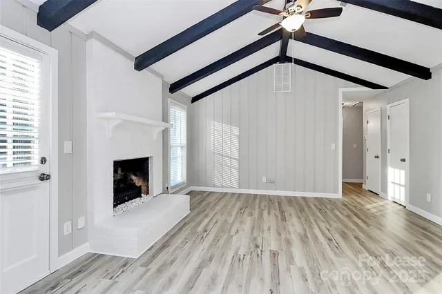 a view of a livingroom with wooden floor and staircase