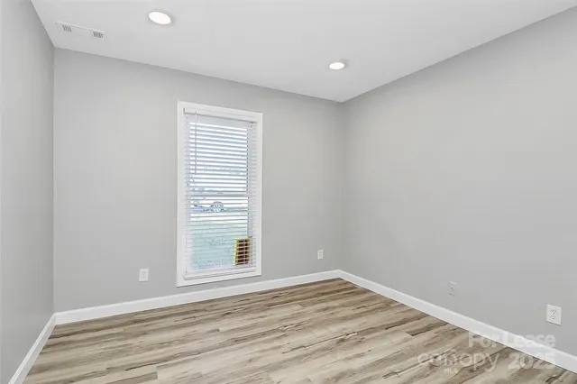 a view of a room with wooden floor and windows