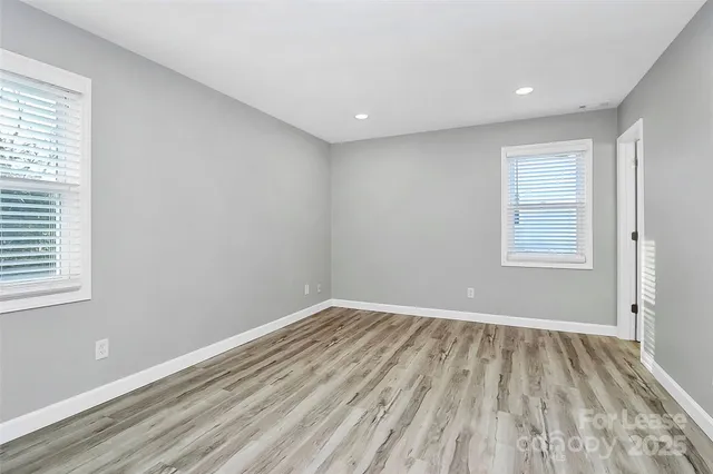 a view of a room with wooden floor and windows