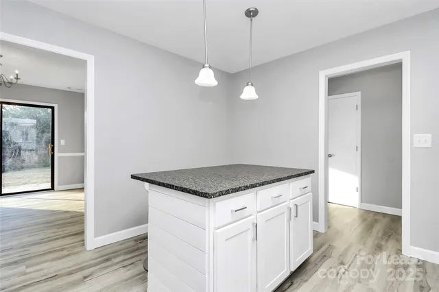a kitchen with a stove and a wooden floor