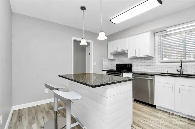 a kitchen with granite countertop a sink cabinets and window