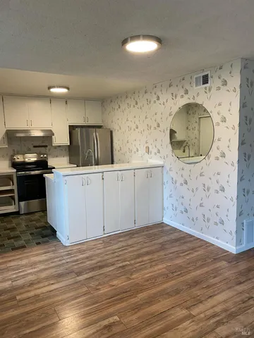 a kitchen with granite countertop a sink a stove and cabinets