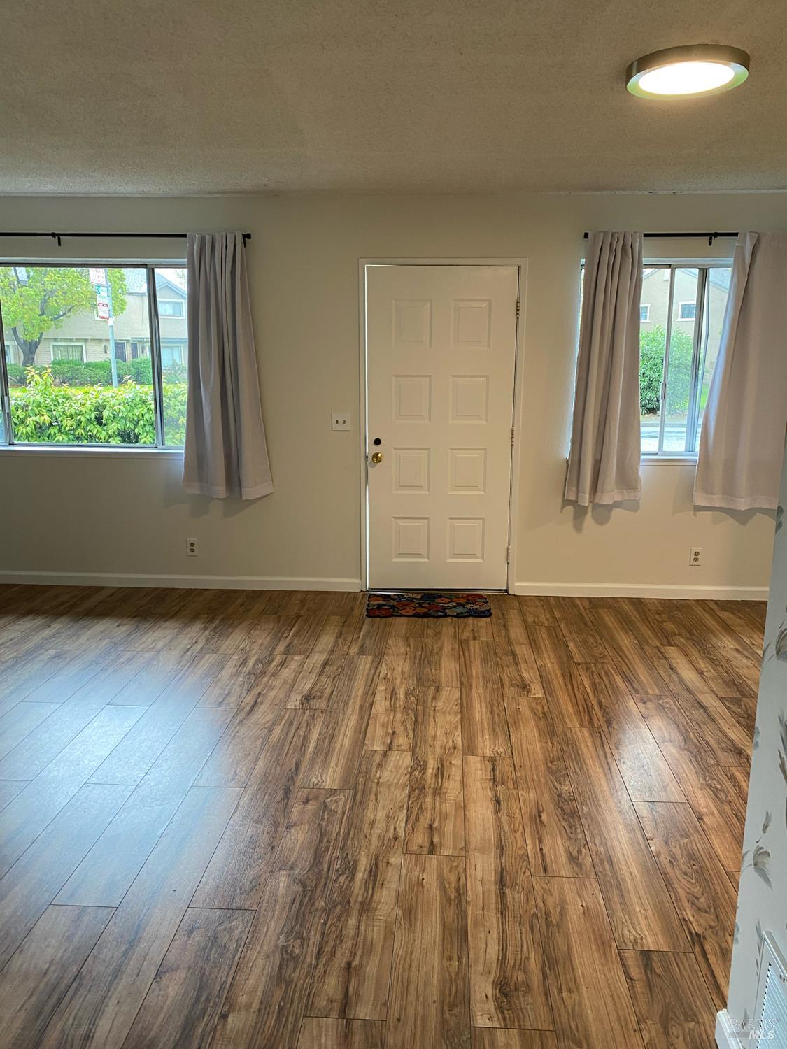 425 Bahia Way San Rafael, CA 94901 - Photo 5 of 18 an empty room with wooden floor and windows