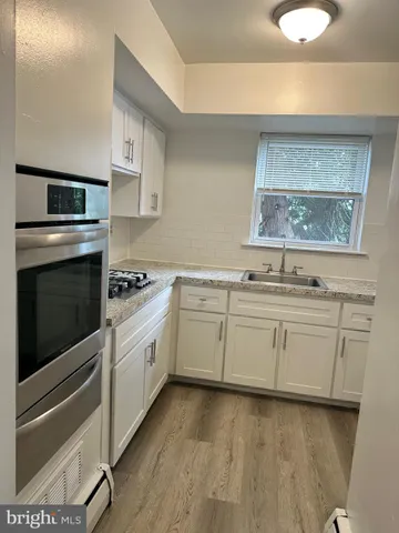 a kitchen with granite countertop white cabinets and white appliances