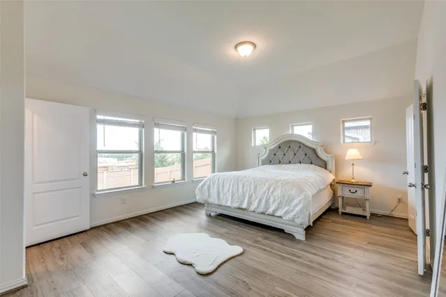 a bedroom with a bed and wooden floor