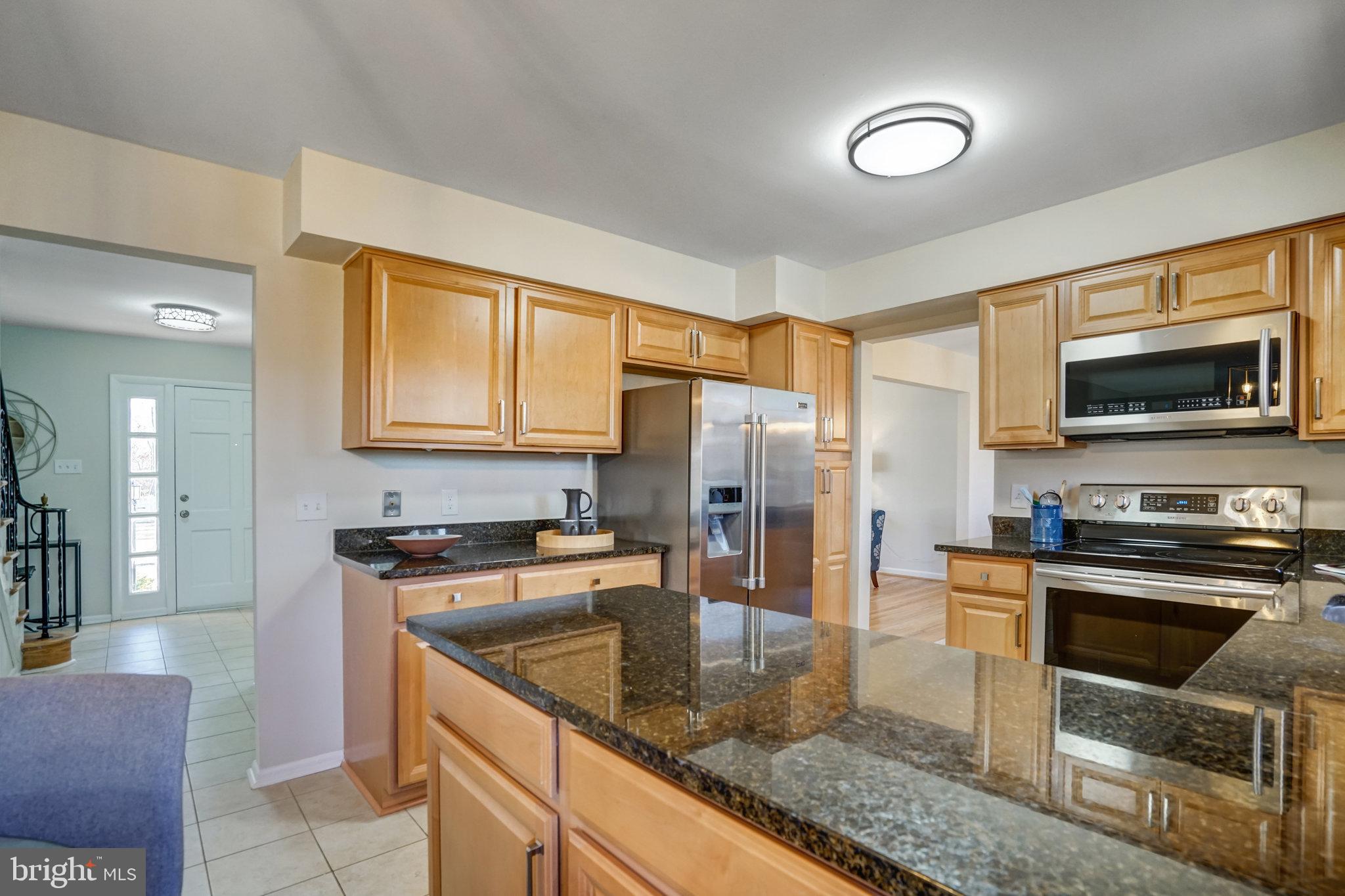 6002 Sherborn Lane Springfield, VA 22152 - Photo 16 of 52 a kitchen with stainless steel appliances granite countertop a stove a sink a microwave a refrigerator and cabinets