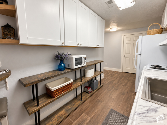 1750 West 4100 North Helper, UT 84526 - Photo 38 of 50 White upper cabinetry, wood-finish flooring, light grey walls, open shelving with wood-finish planks, and a stainless steel sink