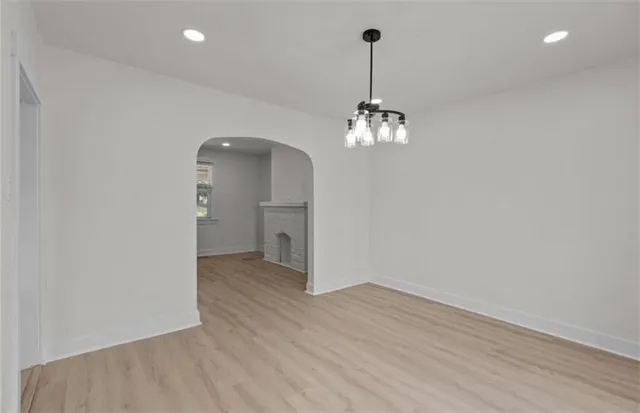 a view of a hallway with wooden floor and a chandelier