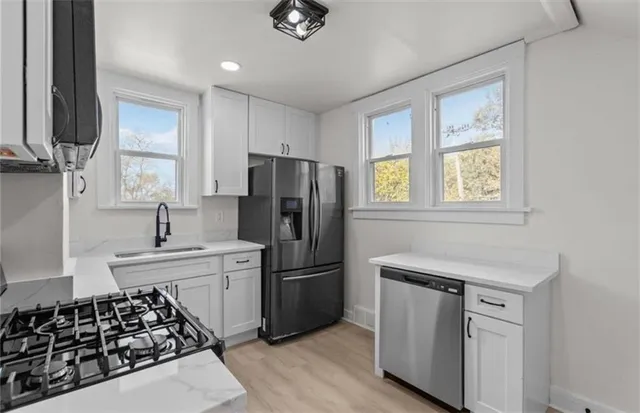 a kitchen with stainless steel appliances a refrigerator and a sink