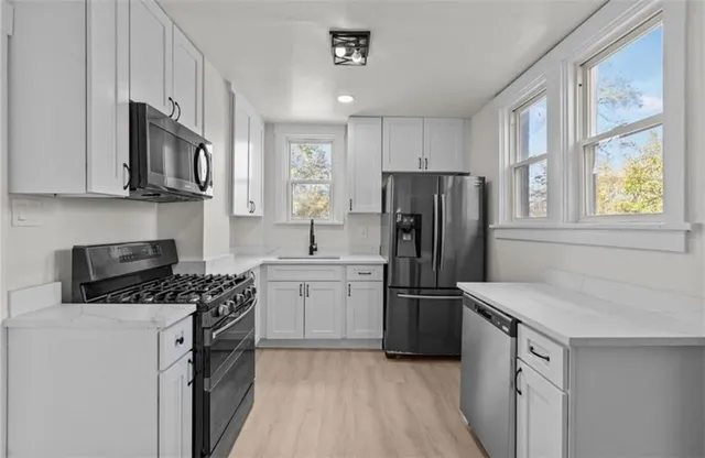 a kitchen with stainless steel appliances granite countertop a refrigerator stove and sink