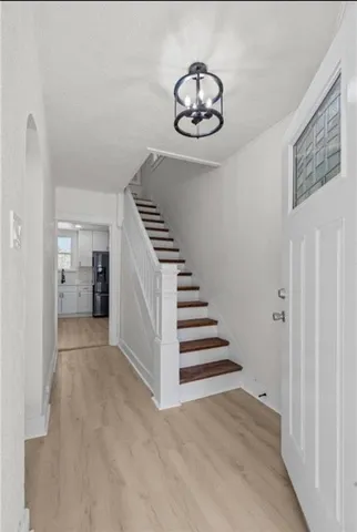 a view of a hallway with wooden floor and stairs
