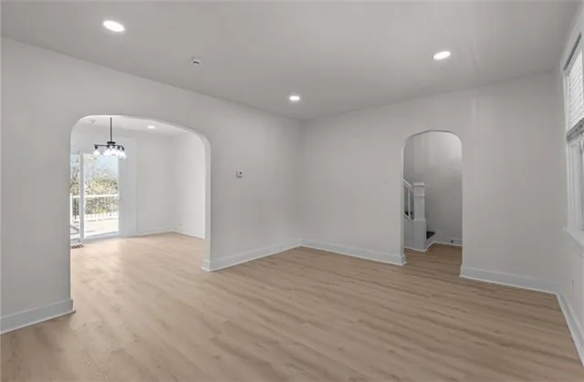 an empty room with wooden floor and mirror