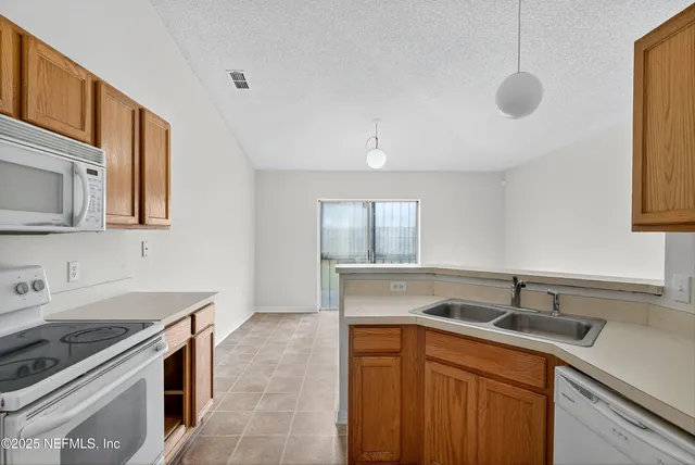 a kitchen with stainless steel appliances granite countertop a sink and a stove