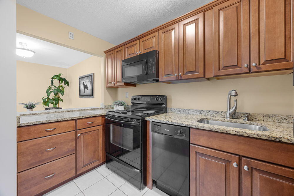 800 Bearses Way, Unit 1WD Hyannis, MA 02601 - Photo 8 of 24 a kitchen with stainless steel appliances granite countertop a sink stove and cabinets