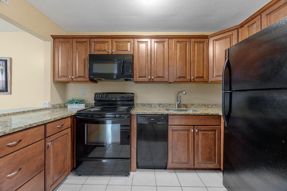 800 Bearses Way, Unit 1WD Hyannis, MA 02601 - Photo 9 of 24 a kitchen with granite countertop a sink stove and refrigerator