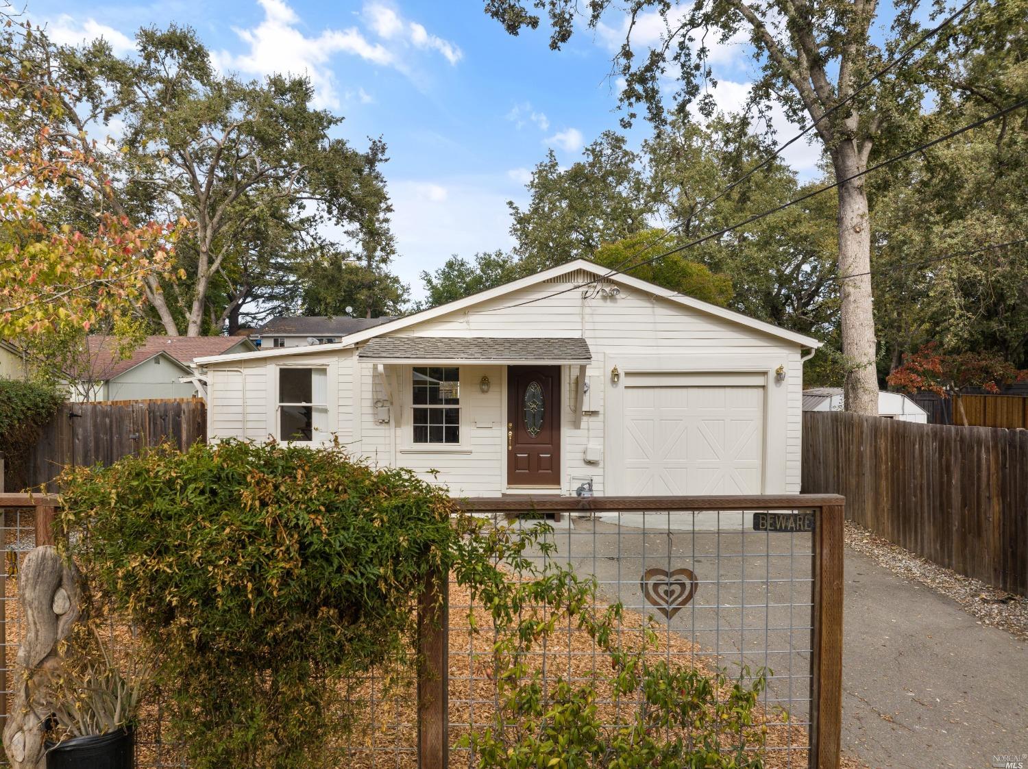 a view of a house with a yard and large tree