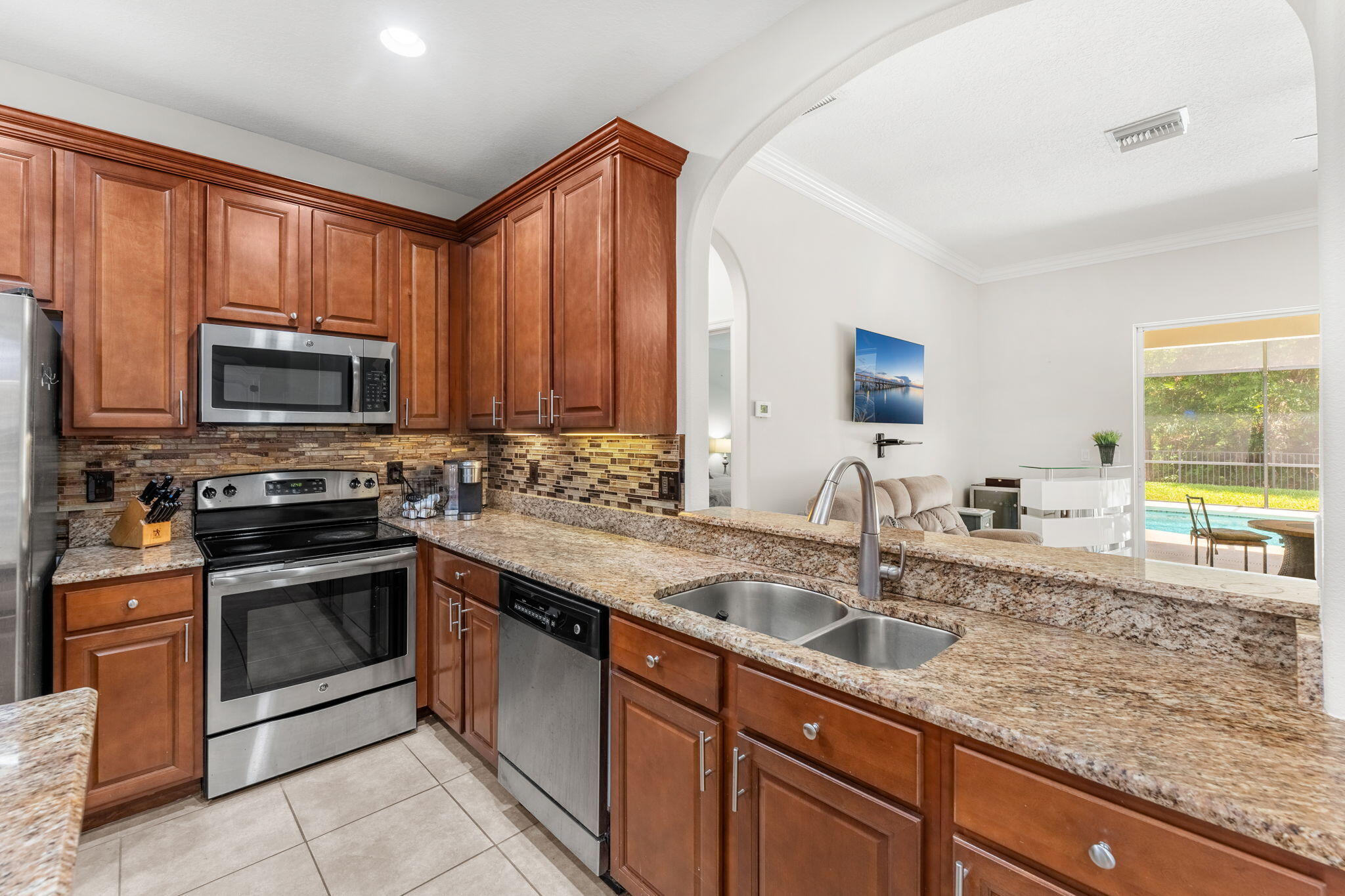 7657 Fieldstone Ranch Square Vero Beach, FL 32967 - Photo 21 of 52 a kitchen with stainless steel appliances granite countertop a sink stove and microwave