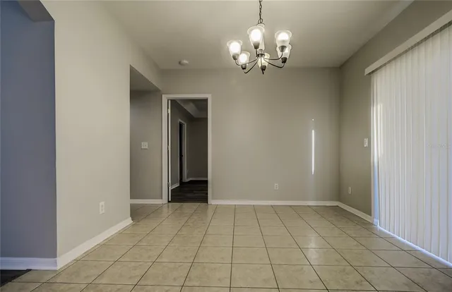 an empty room with wooden floor a ceiling fan and windows