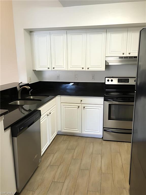a kitchen with granite countertop a stove a sink and dishwasher