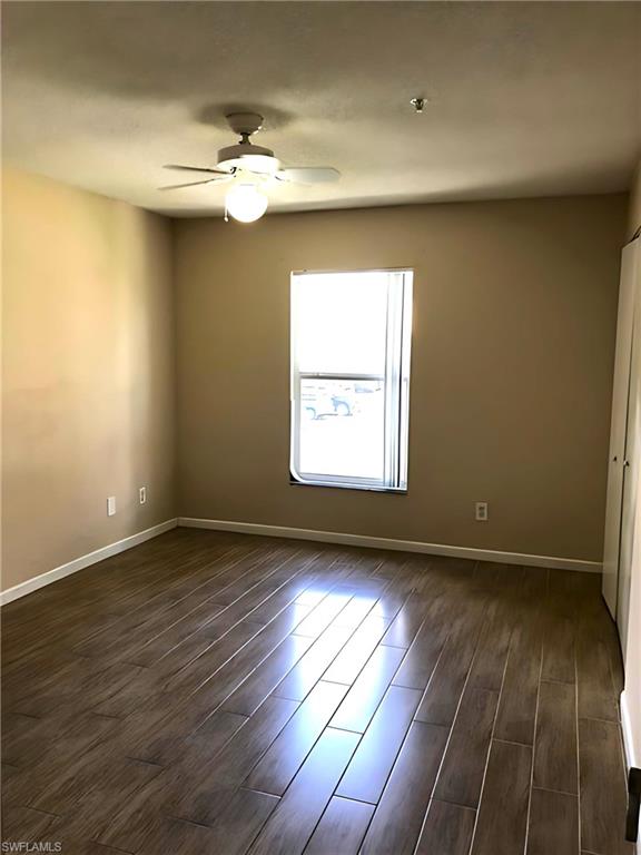 8255 Ibis Club Drive, Unit 508 Naples, FL 34104 - Photo 11 of 14 an empty room with wooden floor and windows
