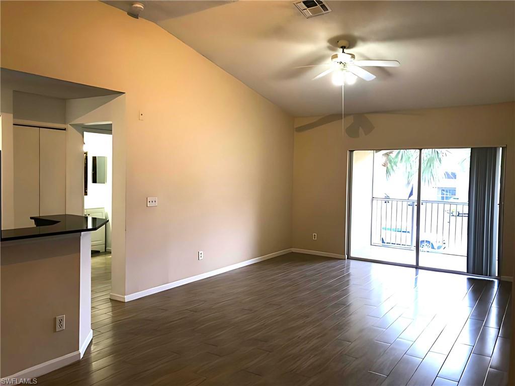8255 Ibis Club Drive, Unit 508 Naples, FL 34104 - Photo 5 of 14 an empty room with wooden floor and windows