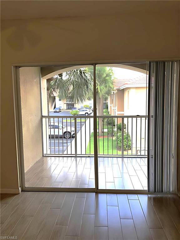8255 Ibis Club Drive, Unit 508 Naples, FL 34104 - Photo 7 of 14 a view of hallway with a large window and wooden floor