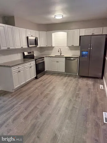 a kitchen with stainless steel appliances a refrigerator sink and microwave